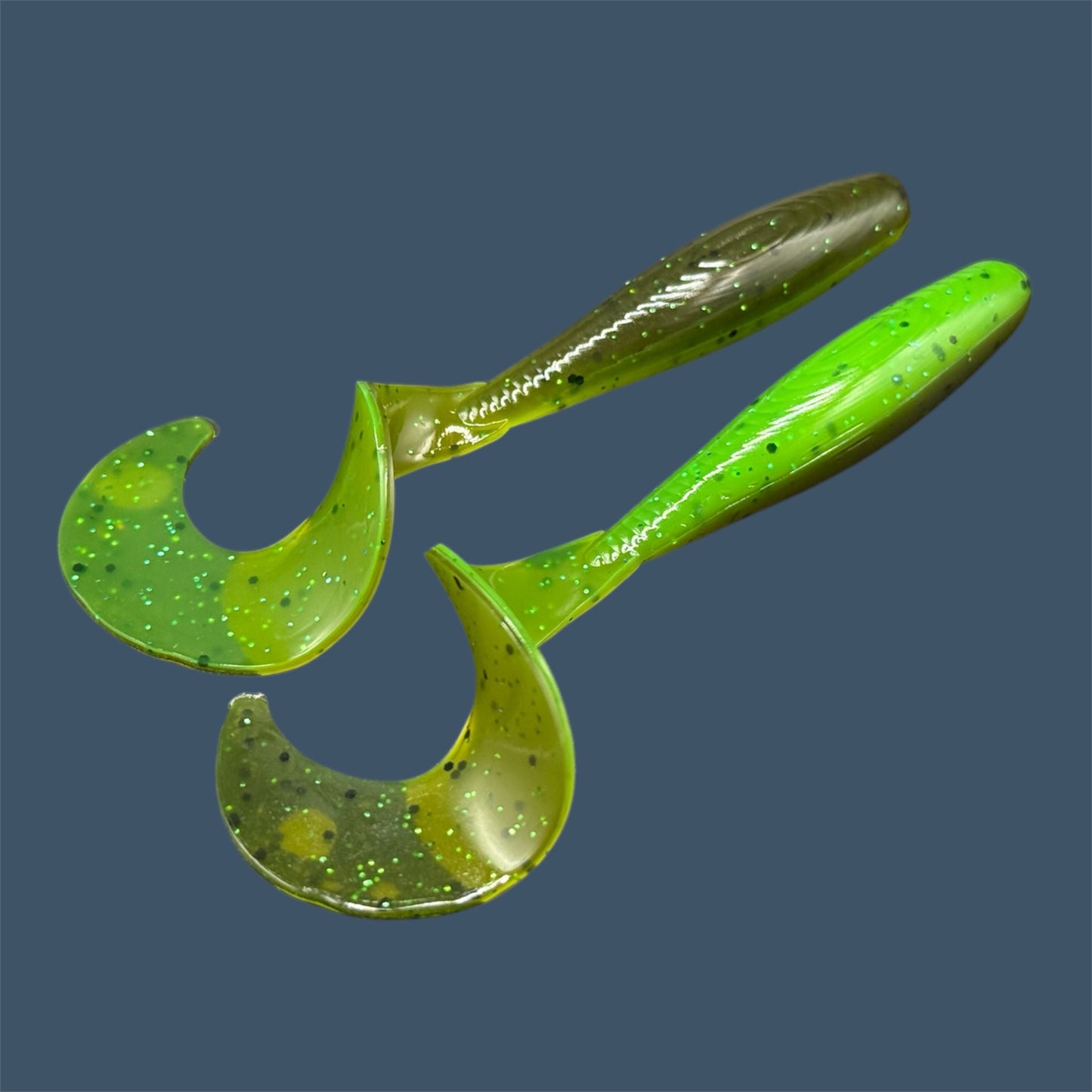 Single Tail Grub with a thick curl tail for strong water displacement, shown in Envy (Green Pumpkin over Green) a proven fish-catching color suitable for both freshwater fishing and inshore saltwater fishing