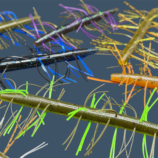 Collection of Fuzzy Boomstick Soft Plastic Bait (Stick worm style bait) with embedded skirt material for Fishing. Shown in an assortment of colors of Fuzzy Lure