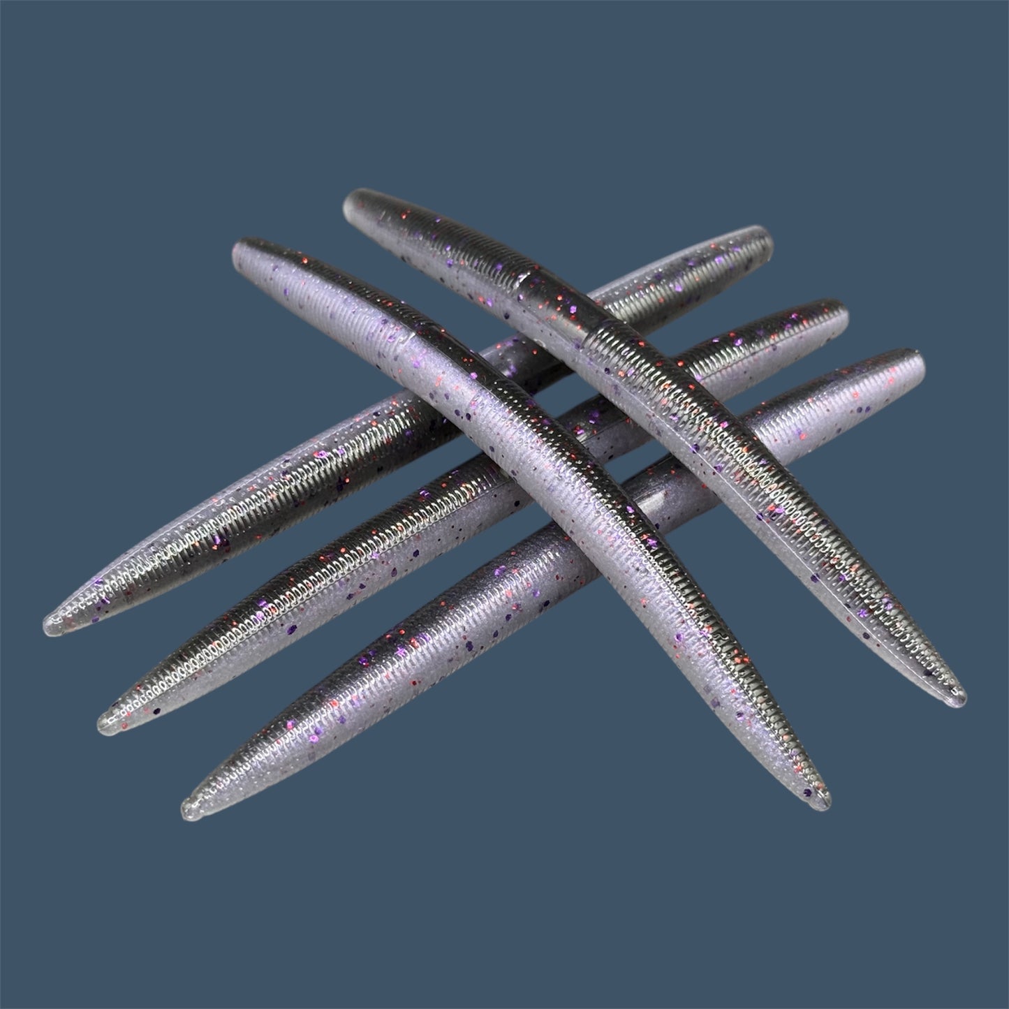 Boomstick is a senko-style stickbait for flipping, skipping, and casting, displayed in Mojo (Black and Purple) for different fishing conditions in freshwater fishing. Great addition to any anglers tackle box