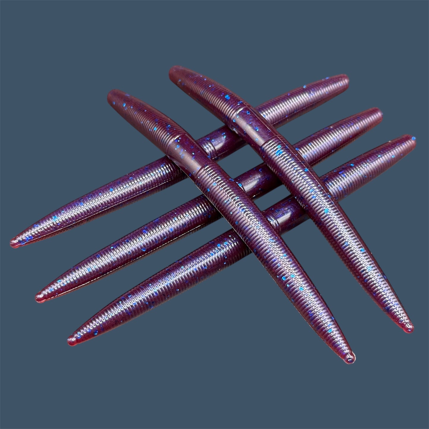 Boomstick is a senko-style stickbait for flipping, skipping, and casting, displayed in Plum Pearl for different fishing conditions in freshwater fishing. Great addition to any anglers tackle box