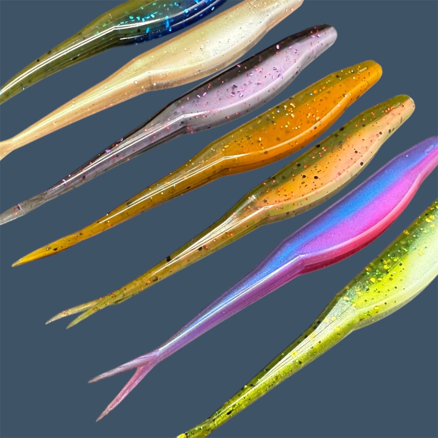 Split Tail Shad soft plastic Fluke style bait with realistic shad appearance, featuring a slotted belly for weedless rigging. Jerkbait shown in various fish-catching colors