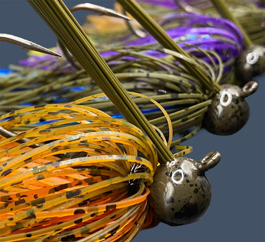 Selection of Football Jigs in various fish-catching colors and patterns, highlighting their robust Mustad Heavy Wire hooks, integrated plastics keepers, and flaring 100% silicone skirts.