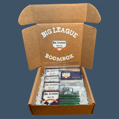 Big League Bait Company Boombox this kit is pictured with several bags of soft plastic fishing lures. All of the soft plastic baits are Big League Bait Company's Boomstick. A senko style stick bait with Wacky Rig O-rings, Eagle Claw EWG 4/0 Hooks and Wacky Rig hooks. 