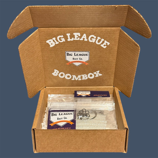 Big League Bait Company Boombox this kit is pictured with several bags of soft plastic fishing lures. All of the soft plastic baits are Big League Bait Company's Boomstick. A senko style stick bait with Wacky Rig O-rings, Eagle Claw EWG 4/0 Hooks and Wacky Rig hooks. 