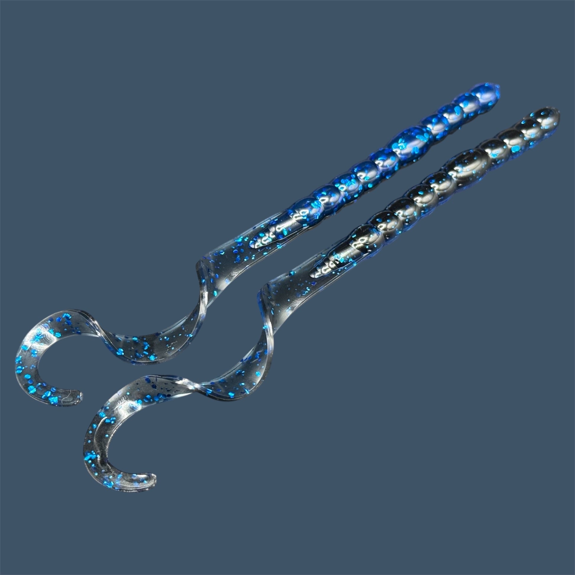 Soft plastic curly/ribbon tail worm 7.5-inch with realistic movement and versatile design for Texas and Carolina rigs. 7.5" Curl Tail Worm shown in Black Sapphire (Black and Blue)