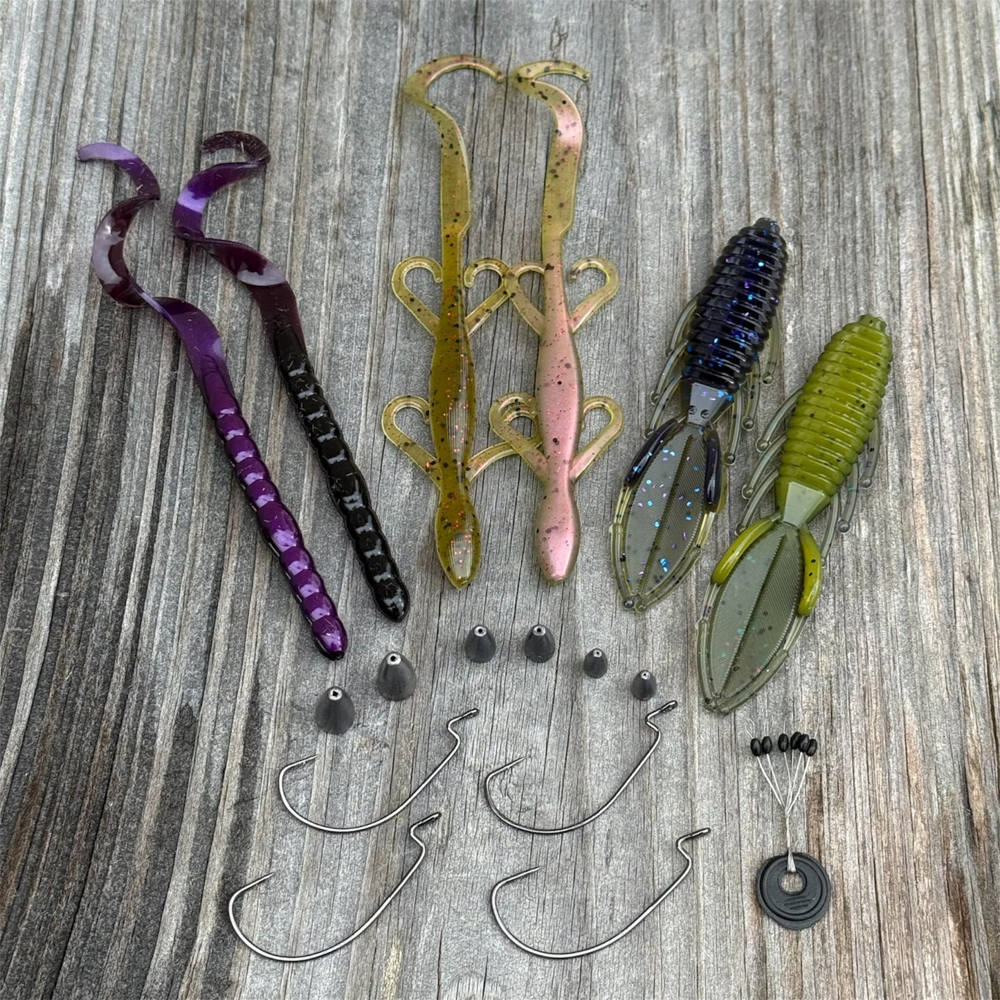 Assorted fishing lures and hooks on a wooden surface